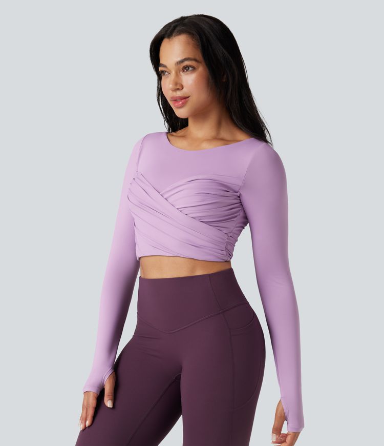 push-up-top mit vorgeformtem spacer rundhalsausschnitt langen Ärmeln und daumenlöchern kurzem schnitt und überkreuztem bein – ideal für yoga und sport.