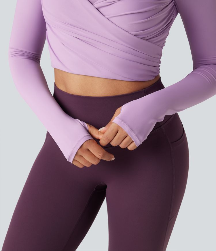 push-up-top mit vorgeformtem spacer rundhalsausschnitt langen Ärmeln und daumenlöchern kurzem schnitt und überkreuztem bein – ideal für yoga und sport.