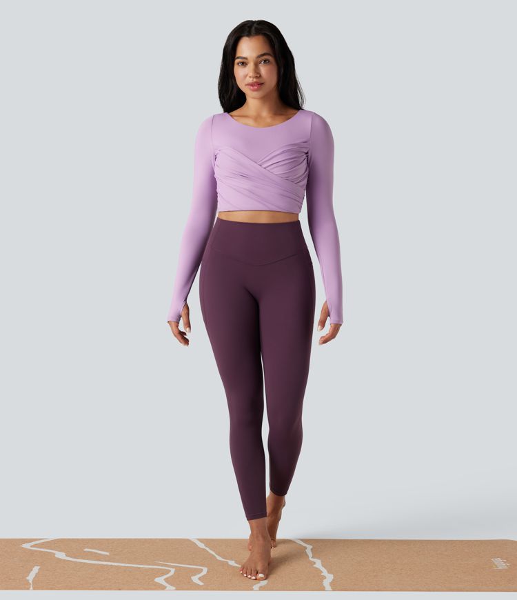 push-up-top mit vorgeformtem spacer rundhalsausschnitt langen Ärmeln und daumenlöchern kurzem schnitt und überkreuztem bein – ideal für yoga und sport.